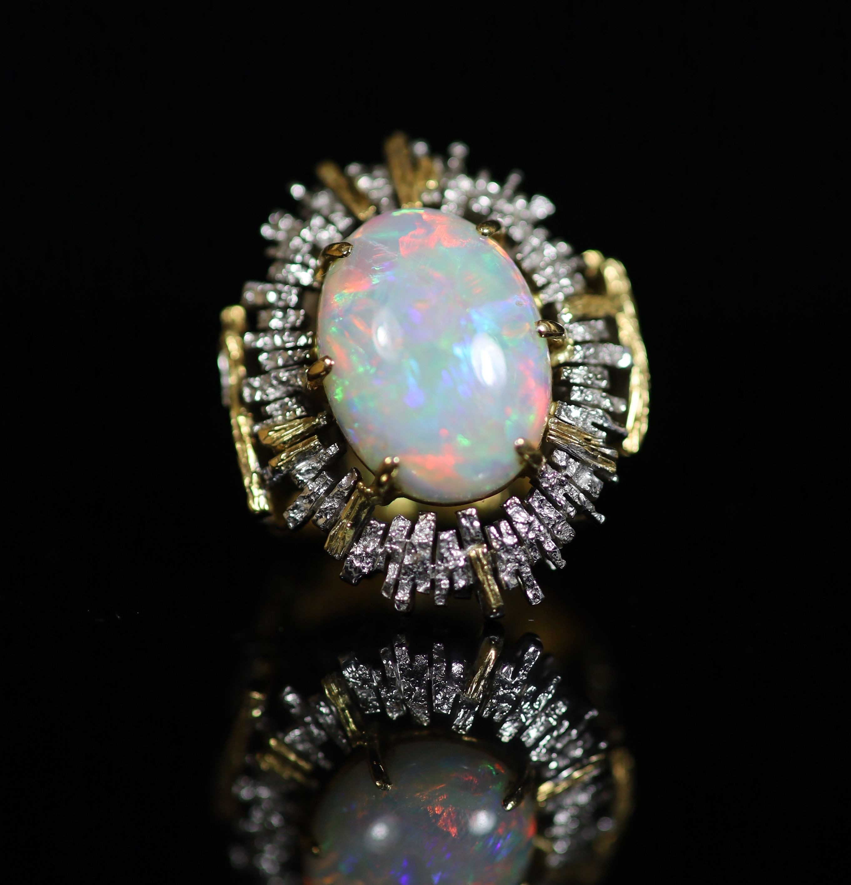 A 1970's? textured two colour 18ct gold and white opal set oval dress ring